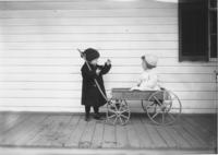 Children with a wagon on a house porch