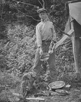 Caretaker on Couching Lion (Camel's Hump) preparing to cook a porcupine