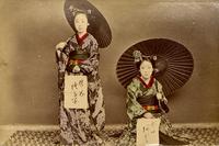 Two women posing for a picture with their calligraphy
