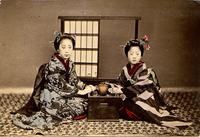 Two women posing with a tea set